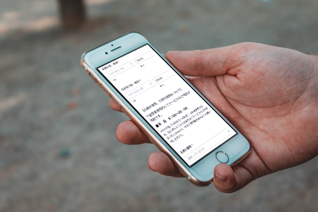 スマートフォンでレンタルオフィスの荷物預かりサービスを予約する利用者の様子